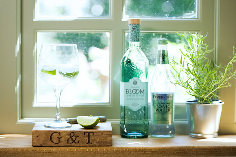 Oak G& To Chopping Board with Bottle of Gin and Fever tree tonic Water with Rosemary by a window